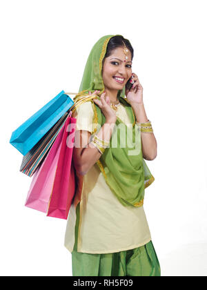 PORTRAIT D'un sikh, SARDANI WOMAN WITH SHOPPING BAGS EN CONVERSATION SUR LE MOBILE Banque D'Images