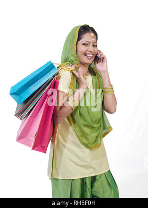 PORTRAIT D'un sikh, SARDANI WOMAN WITH SHOPPING BAGS EN CONVERSATION SUR LE MOBILE Banque D'Images