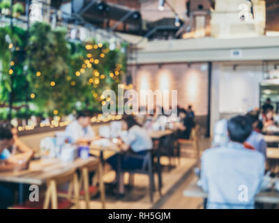 Arrière-plan flou d'un restaurant moderne avec des gens. Abstract blurred beaucoup de gens assis dans un café avec bokeh. Banque D'Images