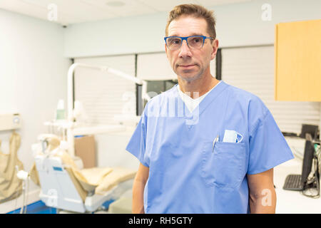 Professional male dentist smiling at camera in dental office Banque D'Images
