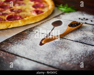Poivre noir dans une cuillère en bois sur la table de cuisine Banque D'Images