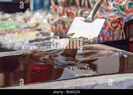 Libre d'un artisan travailleur chocolat chocolat fusion mélange avec des spatules sur une table en marbre. Banque D'Images