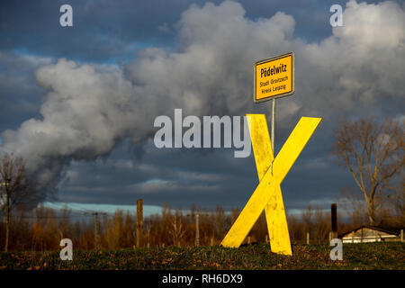 29 janvier 2019, Saxe, Pödelwitz : un X jaune se situe à la ville signe d'Pödelwitz, derrière elle la vapeur s'élève de ses tours de refroidissement de l'Lippendorf power station. Pour une possible extension de la Vereinigtes Schleenhain mine à ciel ouvert à partir de 2040, le village aurait à céder la place. Certains résidents ont été se défendre contre cela depuis des années et, à la suite de la décision de supprimer progressivement le charbon, exigent maintenant certaines garanties sur l'avenir de la ville. Un bon 75 pour cent des villageois ont déjà abandonné volontairement et grâce à de bons paiements d'indemnisation. Photo : Jan W Banque D'Images