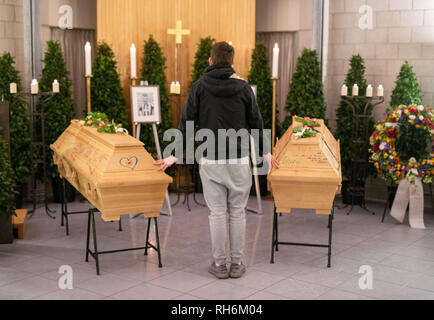 Heroldsberg, Allemagne. 06Th Feb 2019. Un jeune homme pose ses mains sur les deux cercueils à un service funèbre. Une semaine après une querelle fatale dans une gare S-Bahn de Nuremberg, parents, collègues et amis au revoir aux deux jeunes tués à Heroldsberg en franc. Credit : Lino Mirgeler/dpa/Alamy Live News Banque D'Images