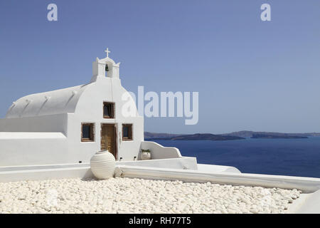 L'emblématique Église blanchie à la chaux, d'Agios Vasilios, situé dans la ville de Oia, Santorin, Grèce, est illustré par un après-midi d'été 24. Banque D'Images