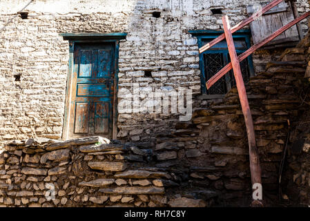 Traditionnel à l'ancienne fenêtre en bois sale et porte dans petit village de montagne au Népal. Banque D'Images