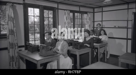 Années 1950, tableau historique d'une classe de dactylographie, montrant les étudiants masculins et féminins assis à un bureau en bois à l'aide de machines à écrire, England, UK. À partir de l'introduction dans les années 1870, des machines à écrire commerciale pour la bureautique, la machine de frappe est devenu un outil pour tous les indepensable écrit et correspondance autres que des lettres personnelles et resta ainsi jusqu'à être remplacé par l'ordinateur personnel et à faible coût et de l'imprimante jet d'encre laser technologies. Banque D'Images