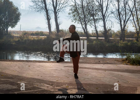 L'homme l'exercice de tai chi au bord de la rivière à Shaxi, un marché de la ville historique, Yunnan, Chine Banque D'Images