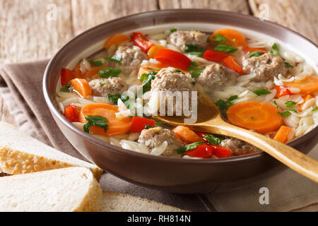 Soupe italienne avec pâtes orzo, boulettes de viande et légumes close-up dans un plat servi avec du pain frais. Banque D'Images