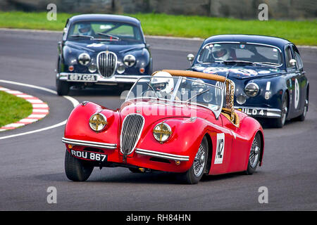 Jaguar Mark II à la poursuite d'un Jaguar XK120 rouge au château de Comb Carrière circuit coin. Banque D'Images