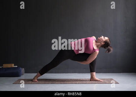 Woman practicing yoga Utthita parsvakonasana exercice, angle de côté poser Banque D'Images