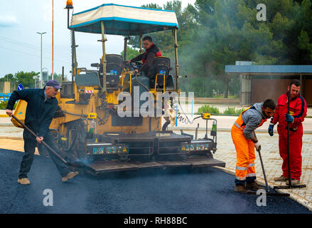 Bari, Italie - 16 mars 2018 : les travailleurs sur l'asphaltage de la machine à paver avec de l'asphalte chauffé à des températures supérieures à 160 ° au cours de route, à la construction de nouvelles Banque D'Images