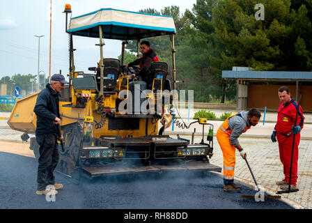 Bari, Italie - 16 mars 2018 : les travailleurs sur l'asphaltage de la machine à paver avec de l'asphalte chauffé à des températures supérieures à 160 ° au cours de route, à la construction de nouvelles Banque D'Images