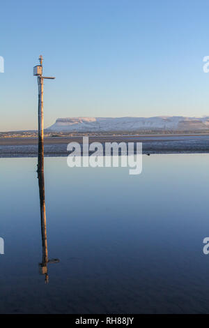 Lever du soleil sur un froid matin d'hiver. Réflexion d'un post en bois, l'Irlande, Ben Bulben Banque D'Images