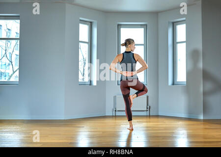 Young woman practicing yoga, travail, porter des vêtements de sport, pantalon et haut, Close up, studio de yoga. Vue arrière Banque D'Images