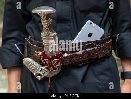 L'Arabie homme avec un iphone et un janbiya à sa ceinture, la Province de Jizan, Jebel Qahar, l'Arabie Saoudite Banque D'Images