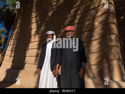 Les agriculteurs de l'Arabie debout devant une ancienne maison de terre, Province de Najran, Najran, Arabie Saoudite Banque D'Images