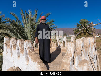 L'Arabie homme debout sur la terrasse de sa maison de terre, Province de Najran, Najran, Arabie Saoudite Banque D'Images