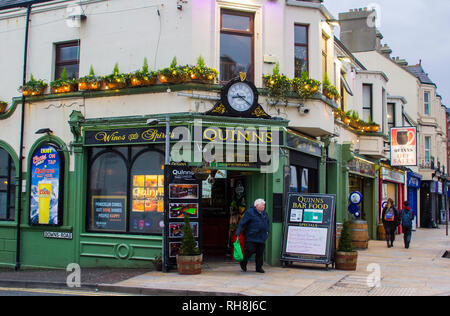 14 Decemberv 2018 Un mécène laissant Quinn's Pub irlandais dans le comté de Down Newcastle après quelques bevvies sur un milieu de l'après-midi d'hiver Banque D'Images