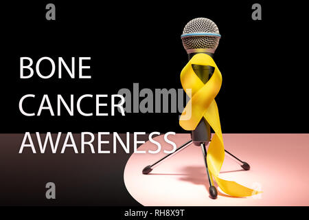 Ruban jaune couleur symbolique de Kaposi cancer des os la sensibilisation et la prévention du suicide avec microphone. Le cancer, la santé, l'aide, de soins, de soutien, d'espoir, de maladie, de soins de concept Banque D'Images