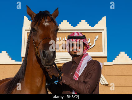 L'Arabie l'homme avec son cheval arabe dans Alhazm stud, Province de Najran, Khubash, l'Arabie Saoudite Banque D'Images