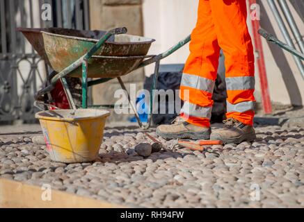 Pose de galets en marbre travailleur Banque D'Images