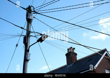 Une masse de fils d'électricité et téléphone frais généraux sur un poteau, côté rue résidentielle, dans le hameau de Middleton, île de Wight, au Royaume-Uni. Banque D'Images