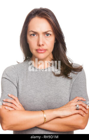 Contrarié insatisfait woman standing with arms folded and looking at camera isolated over white background Banque D'Images