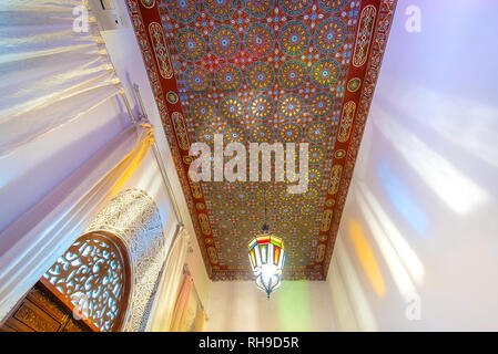 Cour intérieure avec des murs et du sol de mosaïque. Arabesque colorée ornée et traditionnelles sculptures murales au-dessus d'un riad marocain en . Banque D'Images