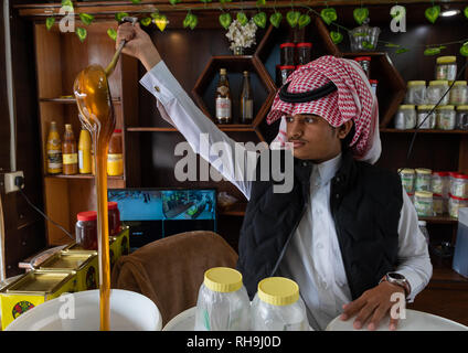 L'Arabie man selling miel dans une boutique, la province d'Asir, Abha, Arabie Saoudite Banque D'Images