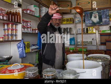 L'Arabie man selling miel dans une boutique, la province d'Asir, Abha, Arabie Saoudite Banque D'Images