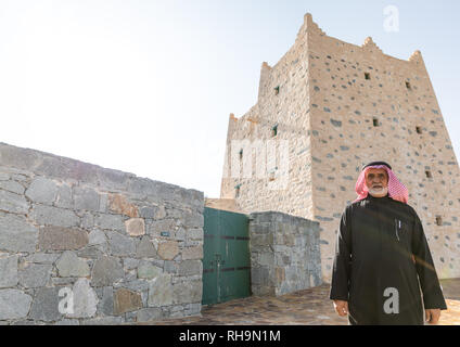 L'Arabie homme debout en face d'une vieille maison traditionnelle en pierre, province d'Asir, Al-Namas, l'Arabie Saoudite Banque D'Images