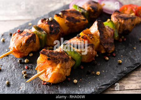 Shish kebab de poulet avec légumes sur pierre noire Banque D'Images