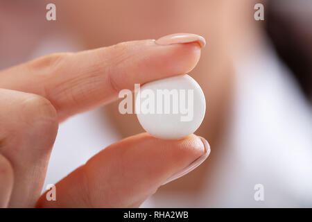 Close-up de la main de femme montrant Tablette ronde blanche Banque D'Images