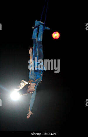 Numéro de cirque. Fille mince montrant truc pendant l'exécution d'gymnastes dans circus. L'équilibriste gymnaste sous dôme de cirque Banque D'Images