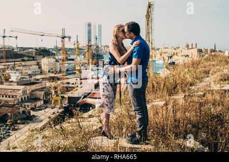 L'homme et la femme s'embrasser, grues et docks sur l'arrière-plan, Malte Banque D'Images