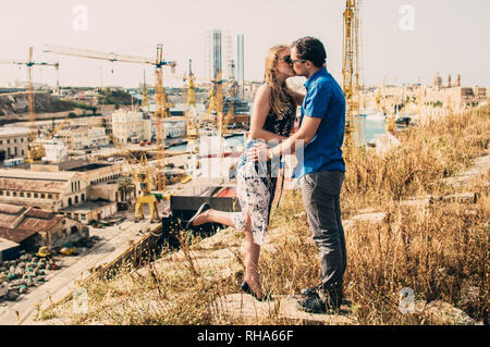 L'homme et la femme s'embrasser, grues et docks sur l'arrière-plan, Malte Banque D'Images