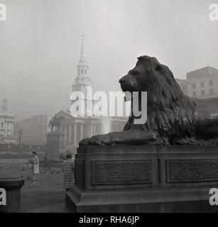 Années 1950, historiques, l'une des statues de lion en bronze qui 'guard'' 'la Colonne Nelson à Trafalgar Square, Londres, Angleterre, Royaume-Uni, conçue par Sir Edwin Landseer. En fait, la commission avait d'abord été attribué à au sculpteur Thomas Milnes. Mais ils n'étaient pas considérées comme assez impressionnant et ainsi le célèbre peintre Edwin Landseer a été demandé de concevoir les lions en 1858. Bien-aimé et bien escaladé...ils sont parmi les plus grandes sculptures en bronze au Royaume-Uni. Banque D'Images