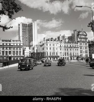 Années 1960, Londres, véhicules automobiles de l'époque au sommet de Hyde Park, près de Marble Arch, montrant un immeuble de bureaux moderne de grande hauteur qui s'élève au-dessus des bâtiments traditionnels de la ville. Le développement de ces grands blocs de bureaux construits à partir de béton préfabriqué a été de changer l'horizon de Londres pour toujours. Banque D'Images