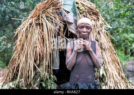 Portrait de tribeswoman pygmée debout devant la hutte primitive, de l'Ouganda Banque D'Images