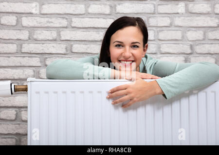 Portrait Of A Young Woman Leaning On radiateur de chauffage Banque D'Images