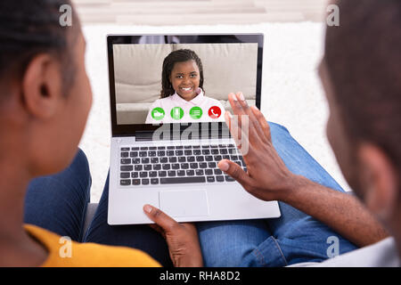 Gros plan d'un couple africain la visioconférence avec leur fille heureuse On Laptop Banque D'Images
