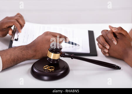 Close-up d'un juge expliquant à son client du contrat avec Golden Gavel et joints toriques Banque D'Images