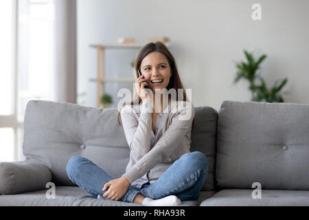 Jeune femme parlant au téléphone de l'appelant à la maison Banque D'Images