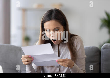 Surpris teen girl holding lettre lecture incroyable news en format papier Banque D'Images
