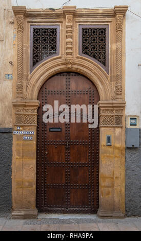 Typique, vieux, brown, finement sculptés, porte cloutée riad marocain et porte cadre et vieille maison à Marrakech, Maroc Banque D'Images