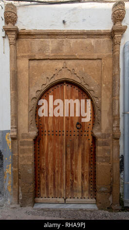 Typique, vieux, brown, finement sculptés, porte cloutée riad marocain et porte cadre et vieille maison à Marrakech, Maroc Banque D'Images