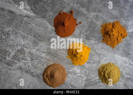 Les poudres d'épices séchées bio mixtes sur un plan de travail de cuisine en marbre photographié ci-dessus de l'arrière-plan Banque D'Images