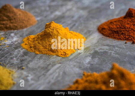 Les poudres d'épices séchées bio mixtes sur un plan de travail de cuisine en marbre background Banque D'Images