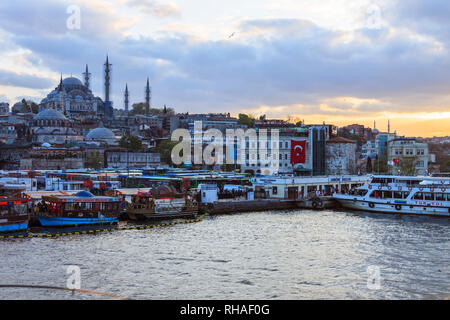Istanbul, Turquie : Cityscape au coucher du soleil avec la mosquée de Soliman et les restaurants de poissons flottants sur la Corne d'or. Banque D'Images